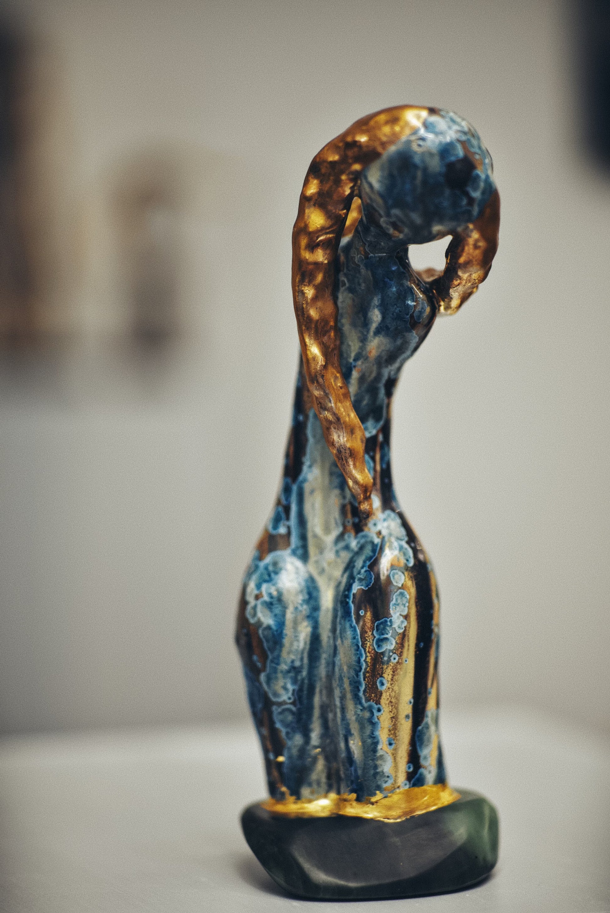 Decorative figurine with blue and gold colors on a plain background