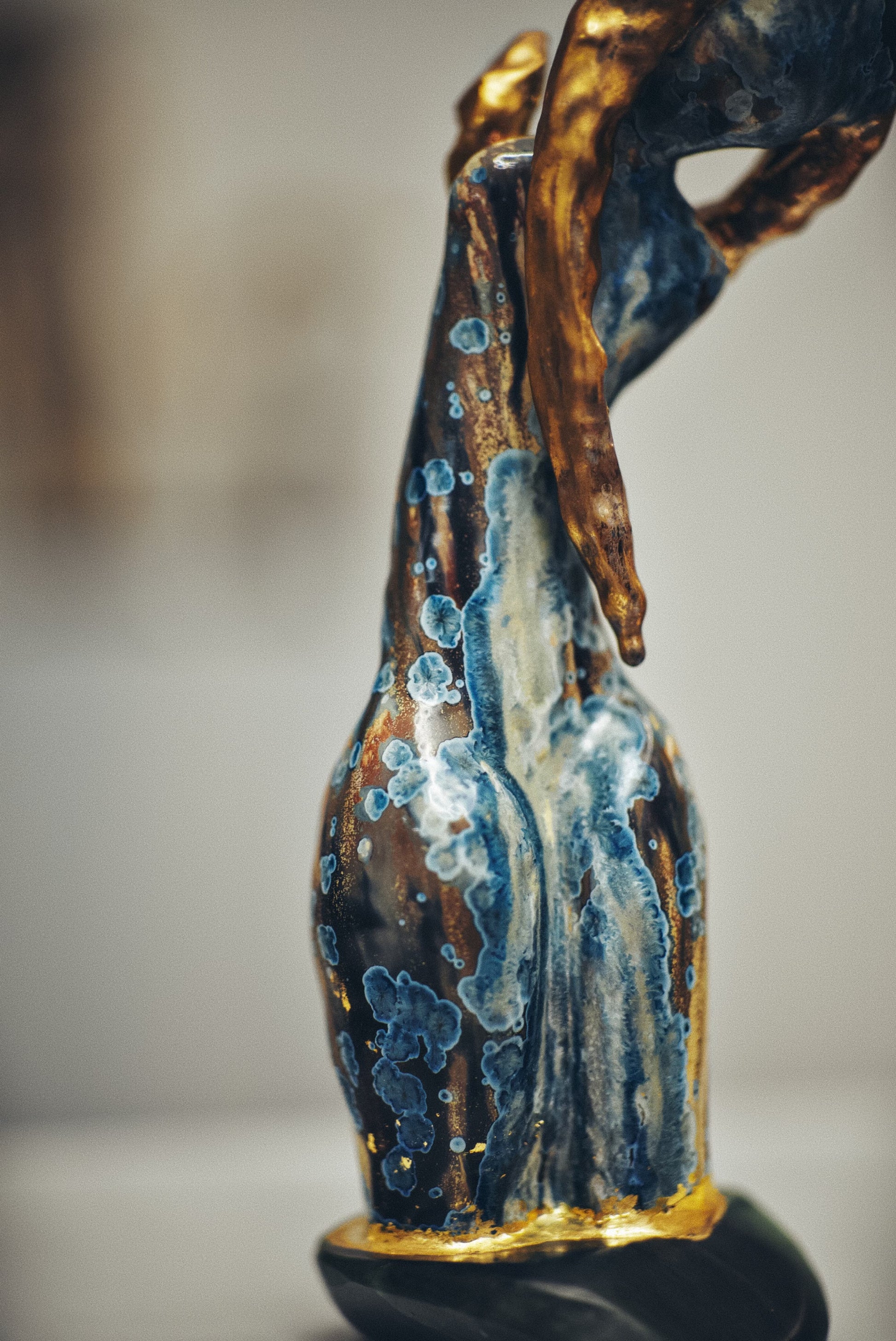 Decorative bottle with blue and gold design on a blurred background