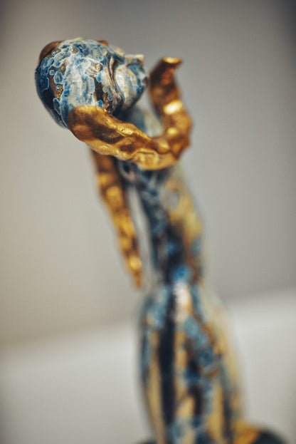 Decorative item with blue and gold design on a blurred background