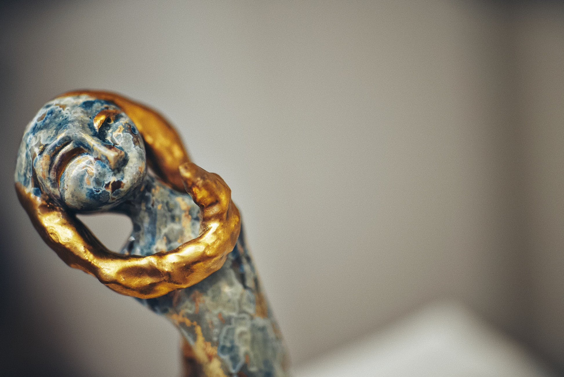 Decorative object with gold and blue detailing on a neutral background