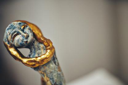 Decorative object with gold and blue detailing on a neutral background