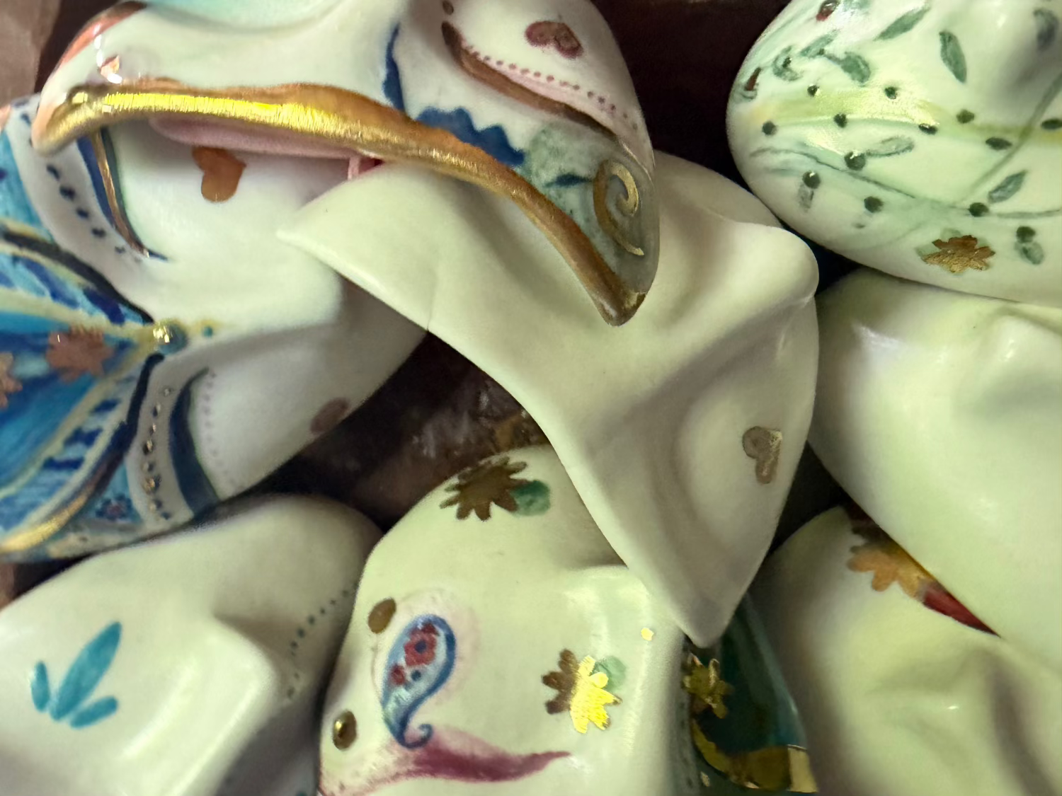 Decorative ceramic hearts with floral patterns on a wooden surface