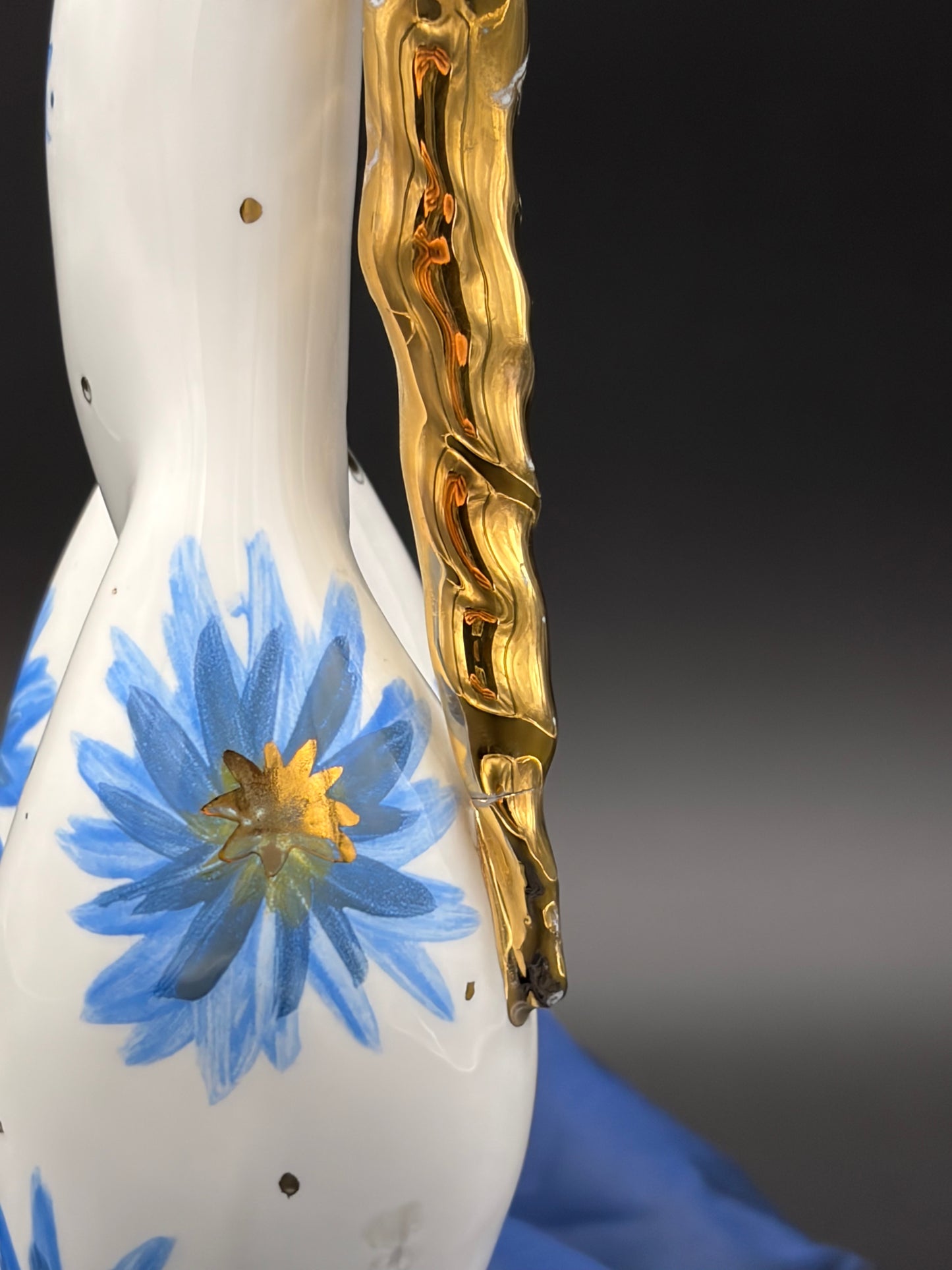 sculpture with blue floral design and gold on a dark background