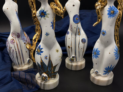 sculptures with floral designs and gold accents on a dark background