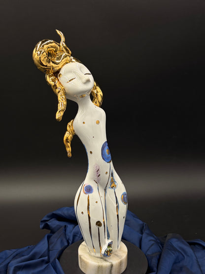  figurine with gold hair and colorful patterns on a dark background