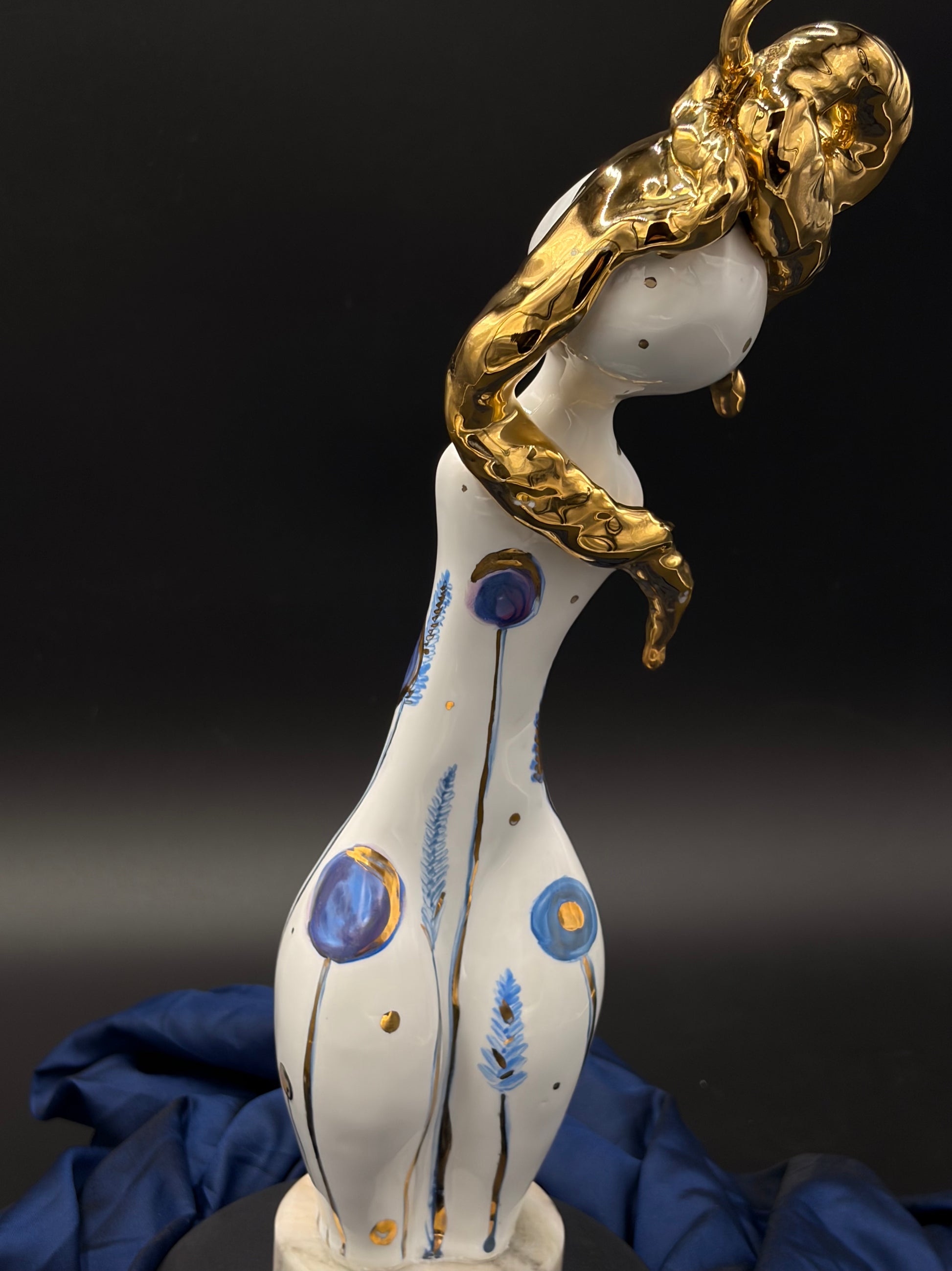 sculpture with gold and blue accents on a dark background