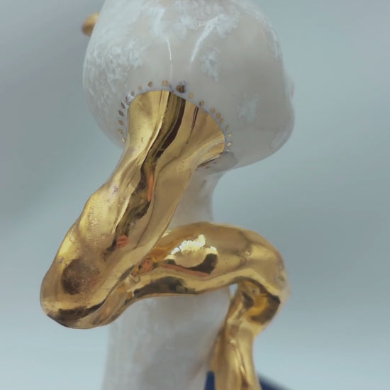 video of white porcelain sculpture turning on a wheel with real gold on antlers