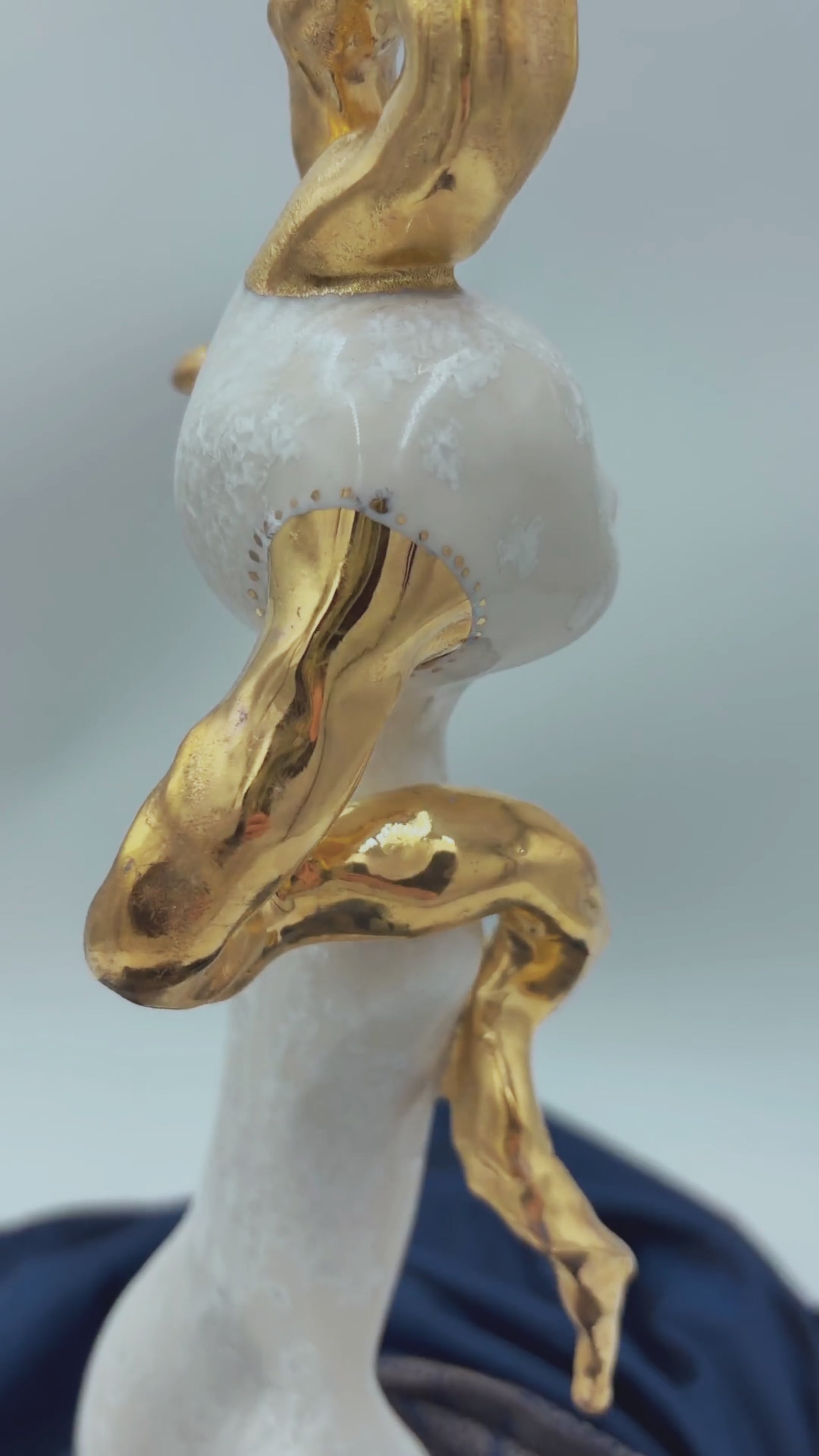 video of white porcelain sculpture turning on a wheel with real gold on antlers