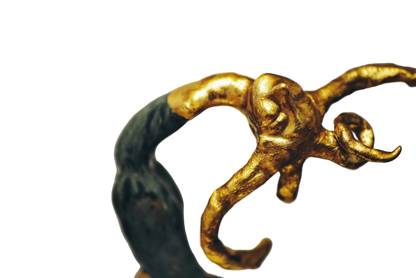 Gold and green decorative object on a gray background