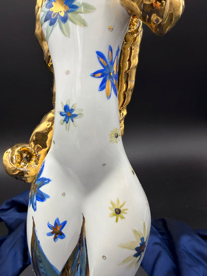 sculpture close up with floral patterns and gold accents on a dark background